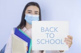 High School Girl With Mask On Her Showing Back To School Message