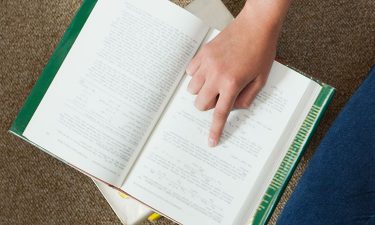 Finger pointing at page in book