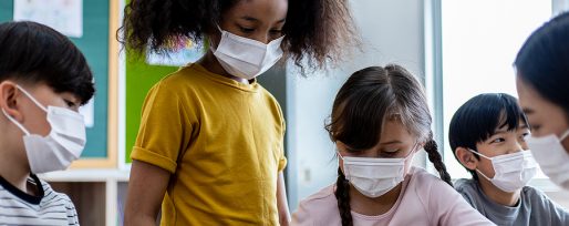 Diversity of children students wearing medical masks in the classroom. An Asian woman teacher and students were discussing the lesson. Concept of prevention of the coronavirus outbreak And new normal